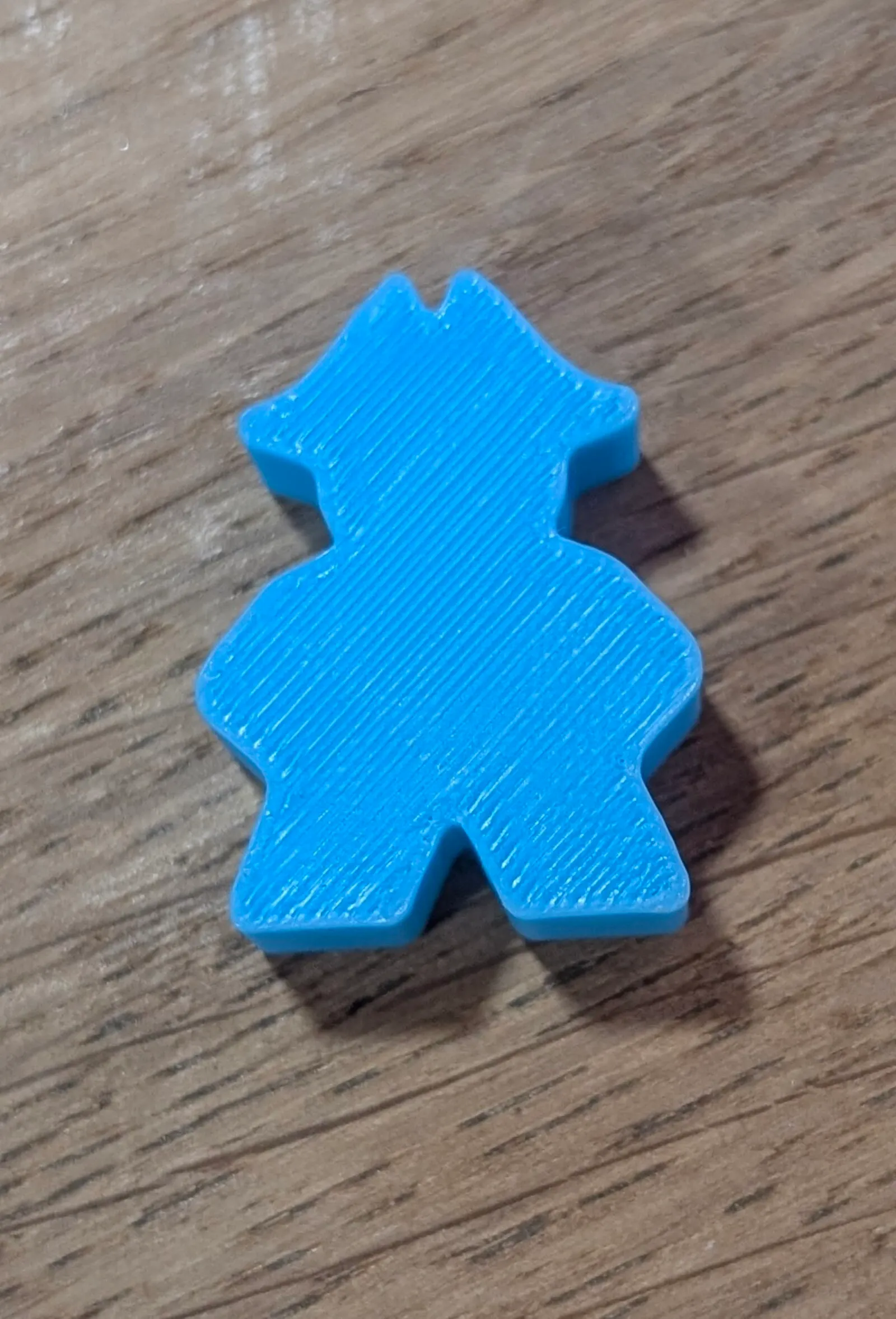 Blau gedruckte Kurierfigur auf einer Holzplatte